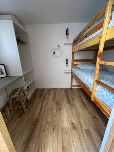 Cette chambre comprend 2 lits superposés et du parquet. dans l'établissement Bleurivage - T3 - deux chambres bord de mer avec piscine et garage, à Sète