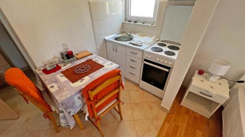 una piccola cucina con un tavolo e una stufa di Apartmani Veronika a Rudina