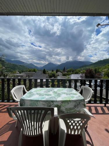 une table et des chaises sur un balcon avec vue dans l'établissement Pyrenees studio view poolyer, à Ayzac-Ost