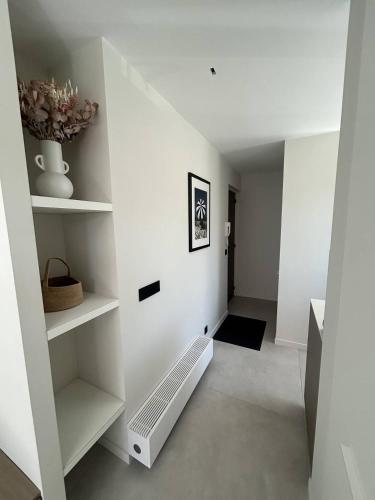 Cette chambre dispose de murs blancs et d'étagères blanches. dans l'établissement Saintpol25, à Le Touquet-Paris-Plage