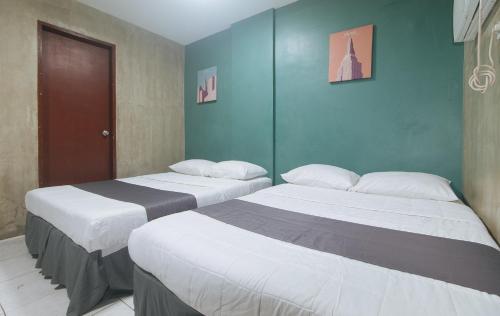 two beds sitting next to each other in a room at Rcee Place by RedDoorz in Cebu City