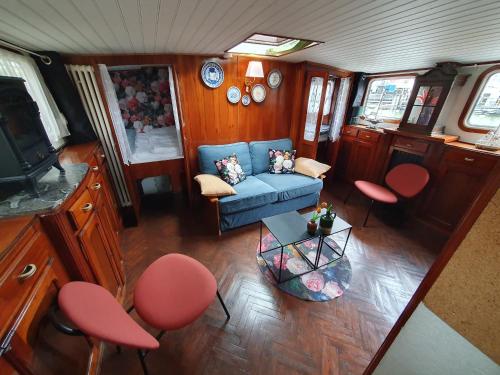鹿特丹Houseboat holiday apartments Rotterdam的客厅配有蓝色的沙发和红色的椅子