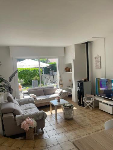 un salon avec un canapé et une télévision dans l'établissement Maison Bohème 6 pers, à Mont-de-Marsan