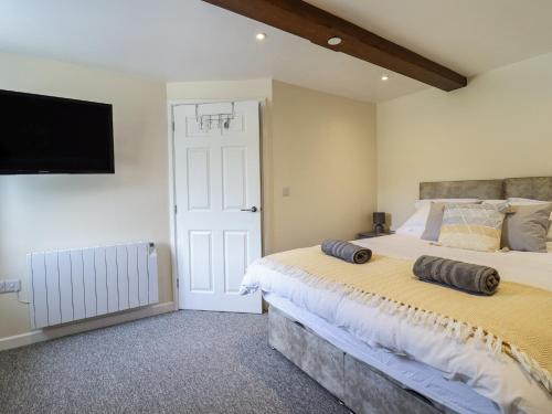 a bedroom with a large bed and a flat screen tv at 1 Y Llew in Llandinam