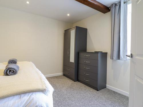 a bedroom with a bed and a dresser with a mirror at 1 Y Llew in Llandinam