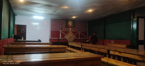 a room with rows of wooden pews in a church at CARAVAN CAPMS in Shimla