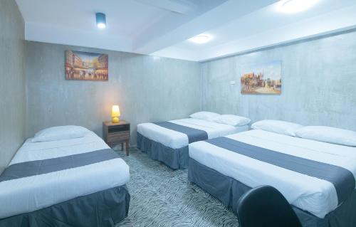 a hotel room with two beds and a table with a lamp at Rcee Place by RedDoorz in Cebu City