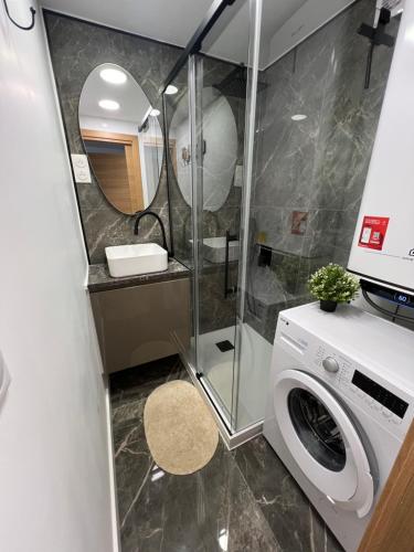 La salle de bains est pourvue d'un lave-linge et d'une douche. dans l'établissement Bleurivage - T3 - deux chambres bord de mer avec piscine et garage, à Sète