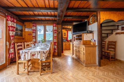 une salle à manger avec une table et une télévision dans l'établissement La Rose des Vents 8-9 pers, aux Gets