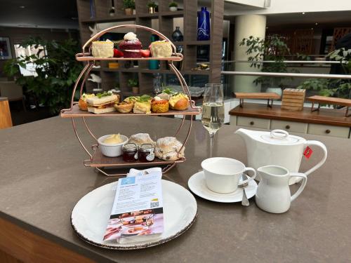 a table with a tray of pastries and cups of coffee at Hilton Cambridge City Centre in Cambridge