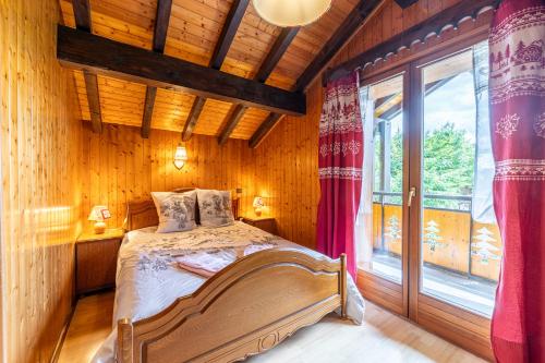 une chambre avec un lit et une grande fenêtre dans l'établissement La Rose des Vents 8-9 pers, aux Gets