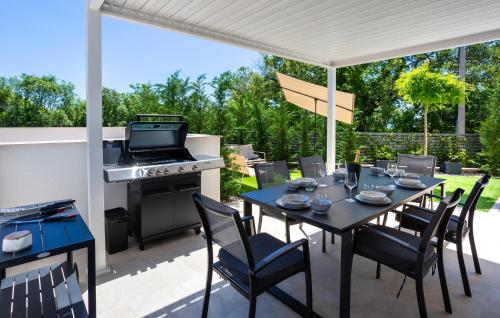 a patio with a table and chairs and a stove at Cozy Home In Linardici in Linardići