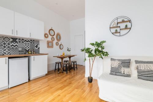 un salon blanc avec un canapé blanc et une table dans l'établissement Charmant 2 pieces central Les Halles a deux pas, à Paris