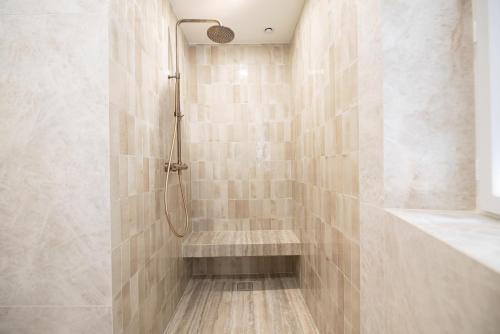 une salle de bain avec une douche avec un banc dedans dans l'établissement Chic Flat in Paris Center, à Paris