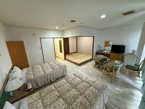 a hotel room with a bed and a desk at Churana Resort Motobu in Motobu