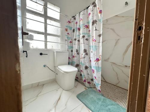 Un baño con inodoro y cortina de ducha. en Habitación individual con baño compartido, en Algeciras