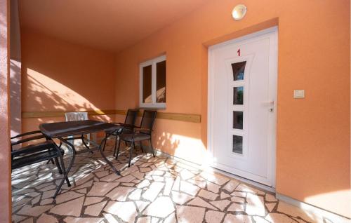 balcón con mesa, sillas y puerta en 2 Bedroom Amazing Apartment In Poljica, en Poljica