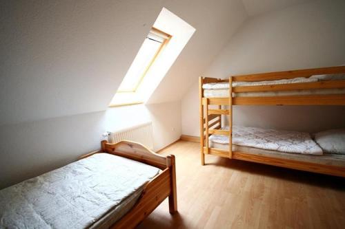 a bedroom with two bunk beds and a window at Ferienhof Peter in Vollerwiek