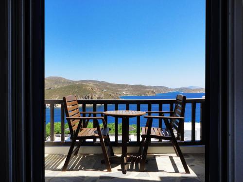 a table and chairs on a balcony with a view of the ocean at Patmos Paradise Hotel in Kámbos