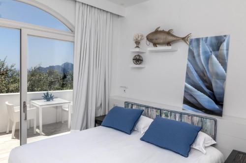 a bedroom with a bed with blue pillows and a window at Relais Blu in Massa Lubrense