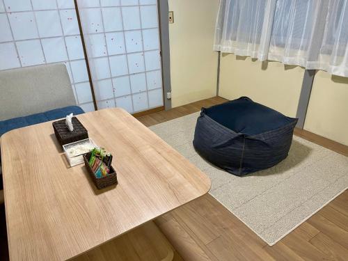 a room with a table and an umbrella on the floor at サニーサイドホステル1号館 in Uji