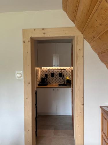 a kitchen with a door leading into a room at Pokoje i apartament z widokiem na Tatry in Kościelisko