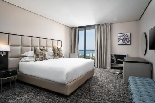 a hotel room with a large bed and a desk at Premier Hotel Umhlanga in Durban
