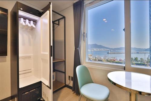 a room with a table and a large window at Jinhae 701 Hotel in Changwon