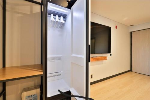 a room with a refrigerator with a tv in it at Jinhae 701 Hotel in Changwon