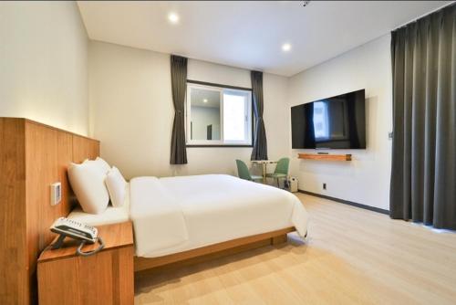 a hotel room with a bed and a television at Jinhae 701 Hotel in Changwon