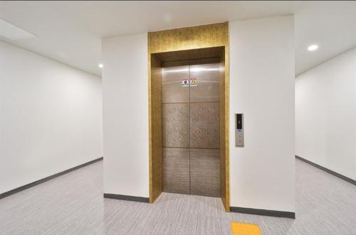 a elevator lobby with a metal door in a building at Jinhae 701 Hotel in Changwon