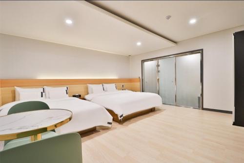 two beds in a room with a window at Jinhae 701 Hotel in Changwon