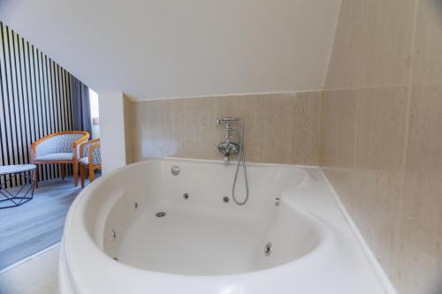 a large white bath tub in a room at Hotel Ciudad Cangas de Onis in Cangas de Onís