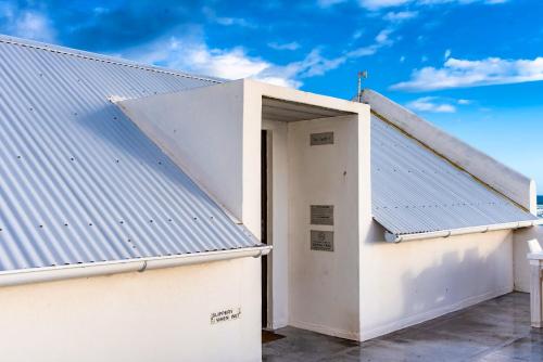 an open door in a white building with a roof at Sea Castle's Paternoster in Paternoster