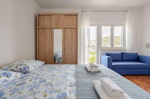 a bedroom with a bed and a blue couch at Waterfront Seaview Apartment Maria in Marina