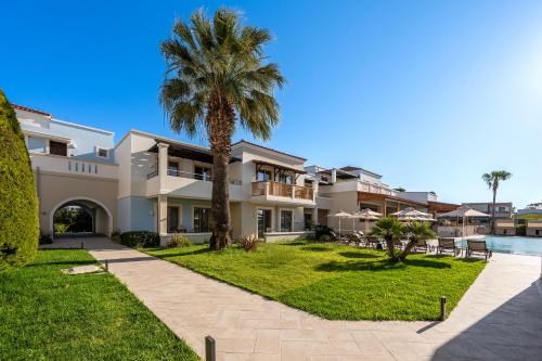 a house with a palm tree and a swimming pool at Aegean Houses in Kos Town