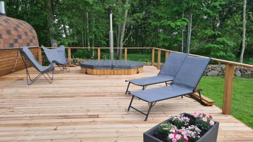 two chairs and a table on a wooden deck at Cozy, private country home with a garden and sauna 