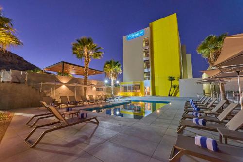 a hotel with a swimming pool and lounge chairs at City Express by Marriott La Paz in La Paz