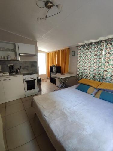 une chambre avec un grand lit et une cuisine dans l'établissement Rose Corse, à Santa-Maria-Figaniella