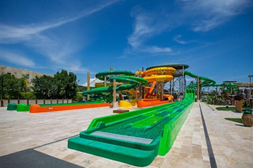 a water park with a green and orange slide at Regnum The Crown in Belek