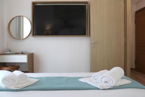 a bedroom with a bed with towels on it at Cocoon Urban Suites in Kavála