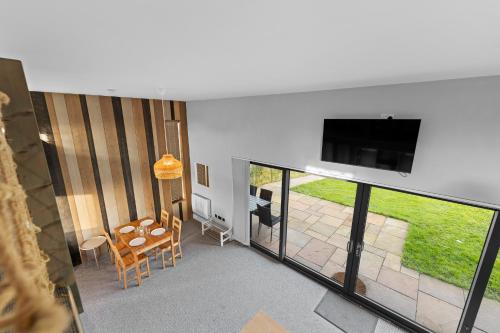 a living room with a flat screen tv on a wall at Cosy Cabin Getaway - Ashbourne in Ashbourne