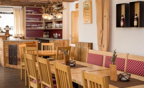 a restaurant with wooden tables and chairs and a bar at Maxlwirt - Gasthaus Pension Gibis in Mauth