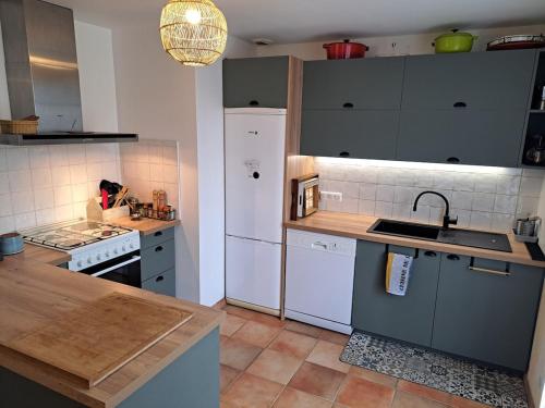 une cuisine avec un réfrigérateur blanc et un évier dans l'établissement Maison avec grand jardin ludique proche mer, à Guérande