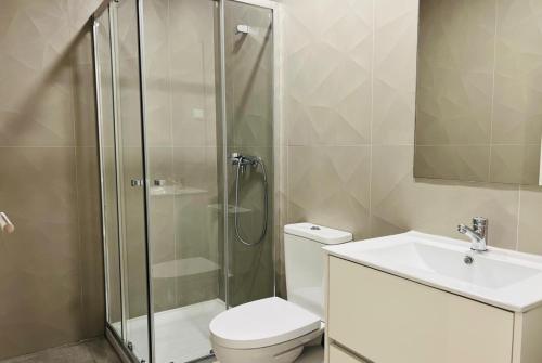 a bathroom with a shower and a toilet and a sink at MiCasa Studios in Coimbra