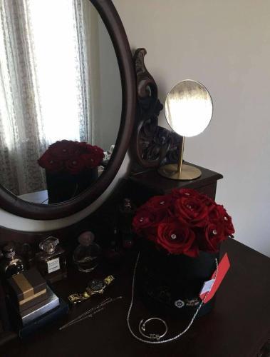 a table with a mirror and a bouquet of roses at Mary's Archontiko in Mesaria