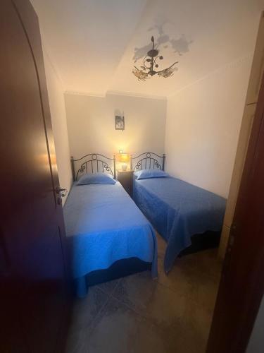 two beds in a room with blue sheets at Mary's Archontiko in Mesaria