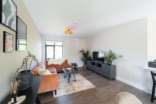 a living room with a couch and a tv at Riverside Dingle - Luxury Apt 2 in Dingle