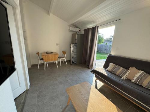 un salon avec un canapé et une table dans l'établissement T2 tout équipé proche des châteaux du médoc et de la côte Atlantique, à Arsac