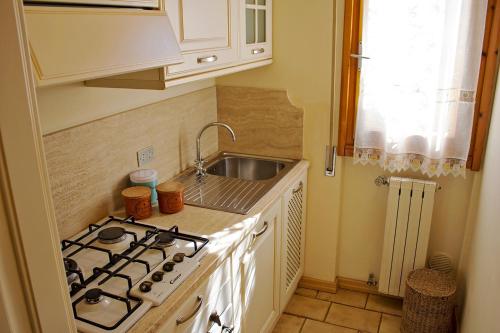 a small kitchen with a stove and a sink at Casetta in Versilia in Viareggio